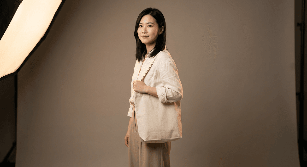 Model holding a plain canvas tote